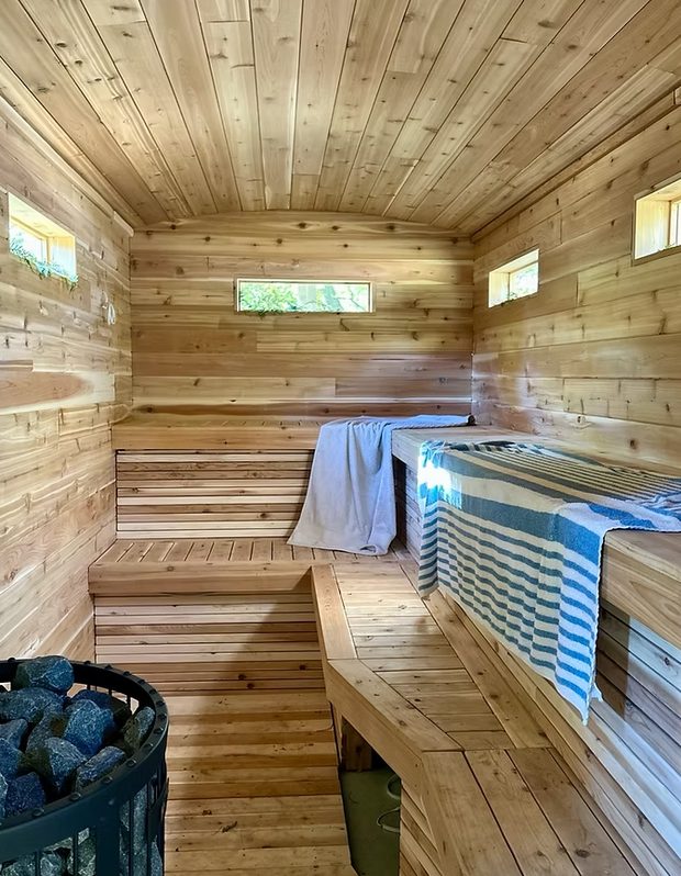 The cedar interior showing both bench tiers and the stove