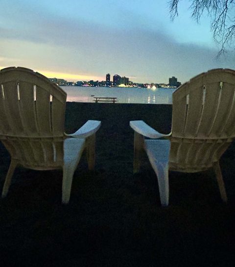 Chairs facing the river at dusk