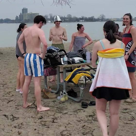Guests standing around on the beach between rounds